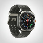 Samsung Watch Ultra 47mm Titanium Blue on a desk beside a smartphone and wireless earbuds.