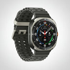 Samsung Watch Ultra 47mm Titanium Blue on a desk beside a smartphone and wireless earbuds.